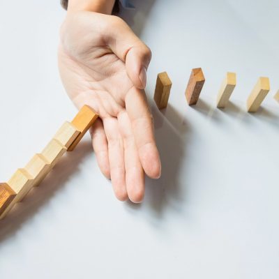 businessman hand stop dominoes continuous toppled or risk with copyspace