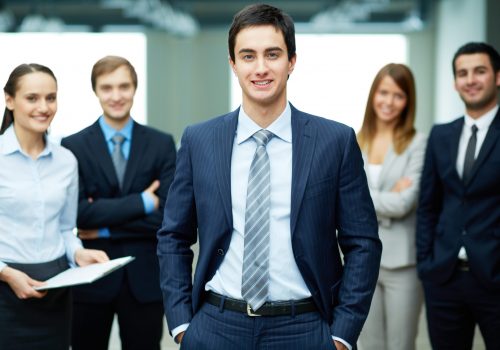 Group of friendly businesspeople with male leader in front